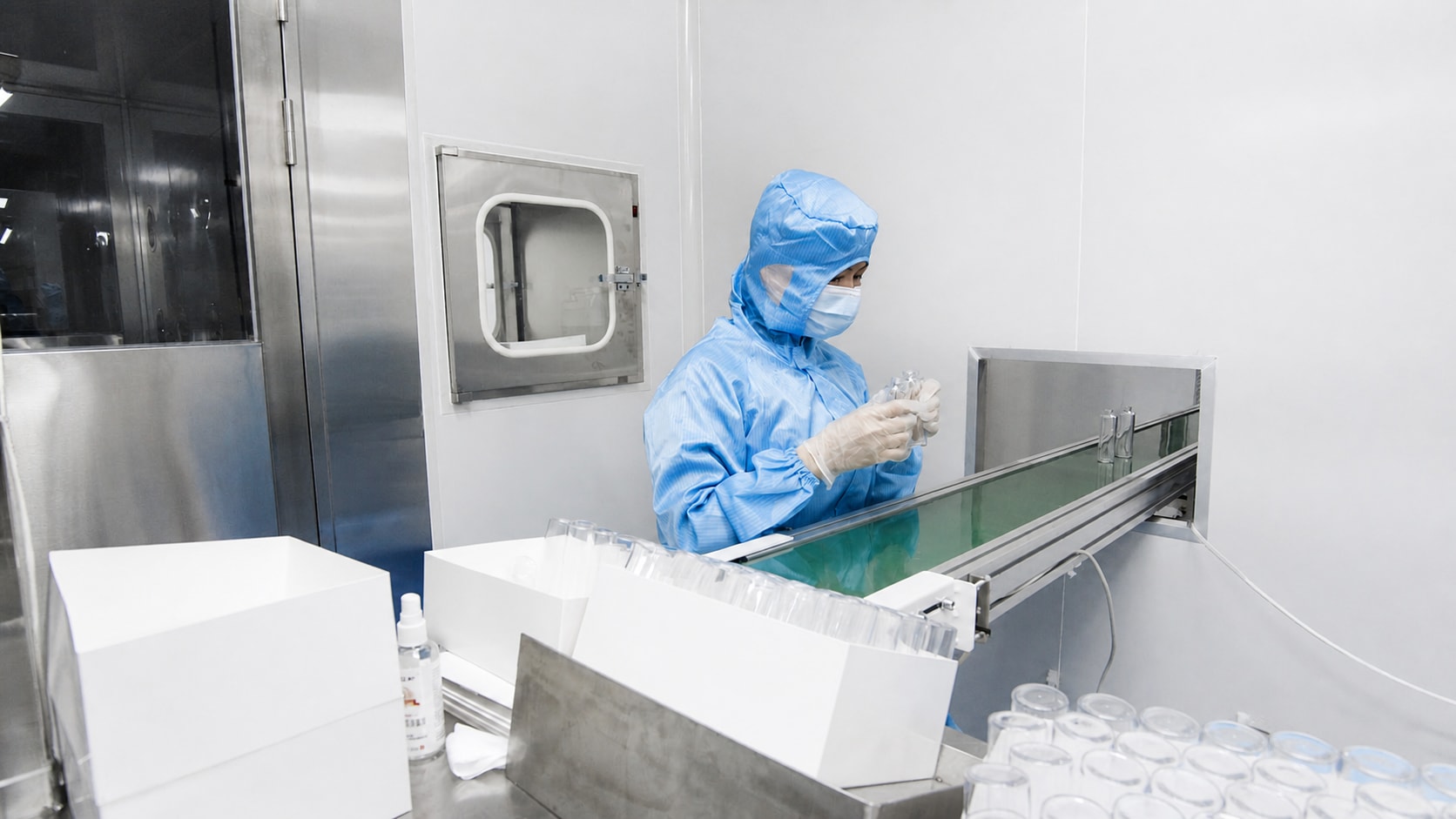 Cleanroommedewerker inspecteert een kunststof laboratoriumcontainer